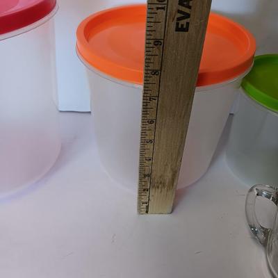 Three plastic lidded food storage containers with Fire King measuring glass
