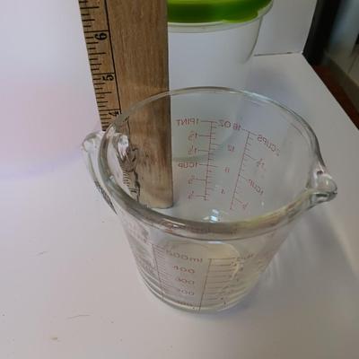 Three plastic lidded food storage containers with Fire King measuring glass