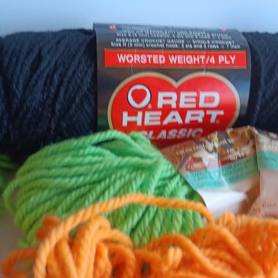 7 skeins of Caron Heavy rug yarn and two black, red heart brand yarn (1 of 2)