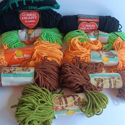 7 skeins of Caron Heavy rug yarn and two black, red heart brand yarn (1 of 2)