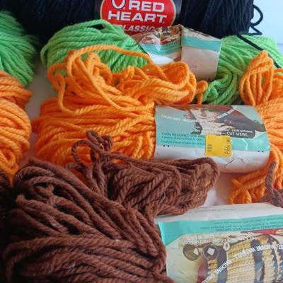 7 skeins of Caron Heavy rug yarn and two black, red heart brand yarn (1 of 2)