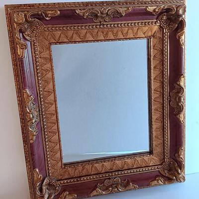 Gold and maroon decorative framed wall mirror with small shelf