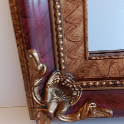 Gold and maroon decorative framed wall mirror with small shelf