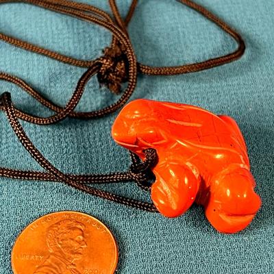 CARVED REDDISH-ORANGE STONE FROG FETISH NECKLACE ON BLACK CORD
