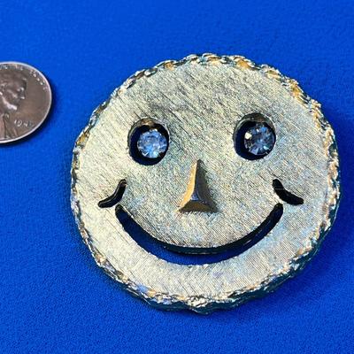 TEXTURED GOLD TONE SMILEY FACE WITH DANGLY RHINESTONE EYES PENDANT/ PIN