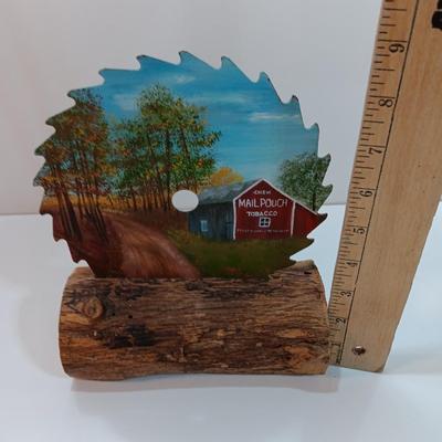 Hand painted saw blade signed by artist Chew Mail Pouch Tobacco barn with log display
