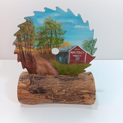 Hand painted saw blade signed by artist Chew Mail Pouch Tobacco barn with log display