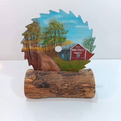 Hand painted saw blade signed by artist Chew Mail Pouch Tobacco barn with log display