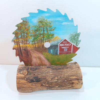 Hand painted saw blade signed by artist Chew Mail Pouch Tobacco barn with log display