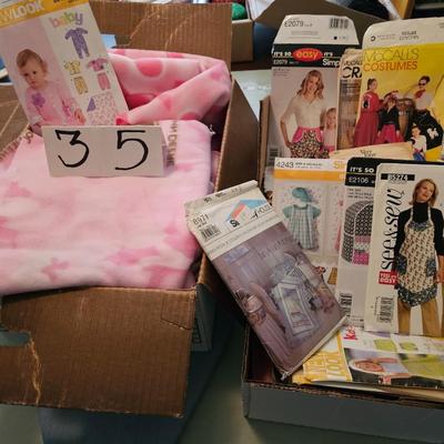 2 boxes of sewing patterns, fabric, and sall tabletop ironing board