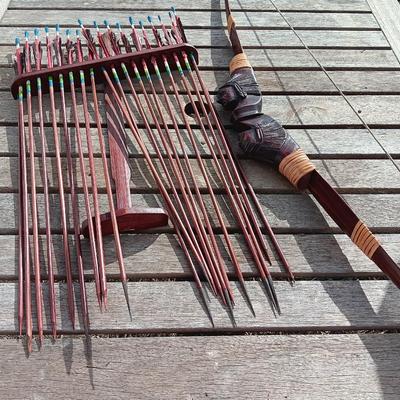 Hand carved two faced Native American head archery decorative bow with arrows.