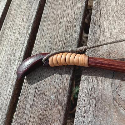 Hand carved two faced Native American head archery decorative bow with arrows.