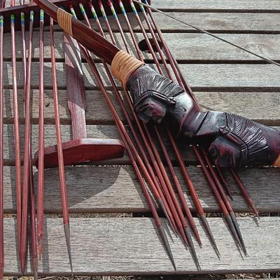 Hand carved two faced Native American head archery decorative bow with arrows.