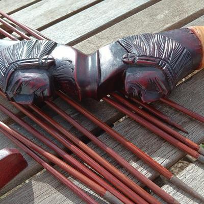 Hand carved two faced Native American head archery decorative bow with arrows.