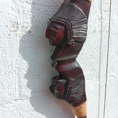 Hand carved two faced Native American head archery decorative bow with arrows.