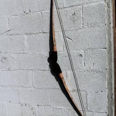 Hand carved two faced Native American head archery decorative bow with arrows.