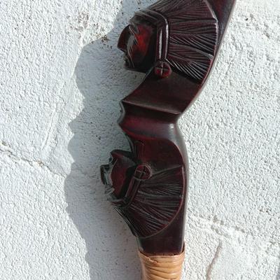 Hand carved two faced Native American head archery decorative bow with arrows.