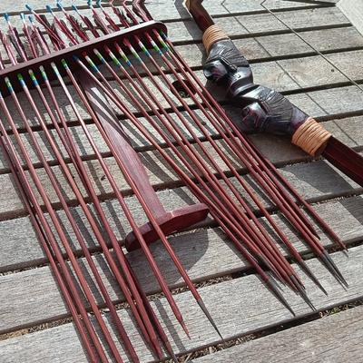 Hand carved two faced Native American head archery decorative bow with arrows.