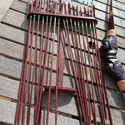 Hand carved two faced Native American head archery decorative bow with arrows.