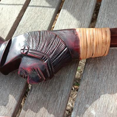 Hand carved two faced Native American head archery decorative bow with arrows.