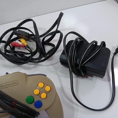 Nintendo 64 with controllers, Zelda game, and cords