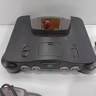 Nintendo 64 with controllers, Zelda game, and cords