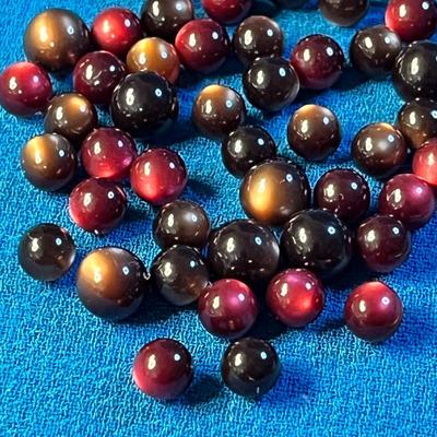 GROUP OF SMALL RED, BROWN IRIDESCENT STONES/BEADS