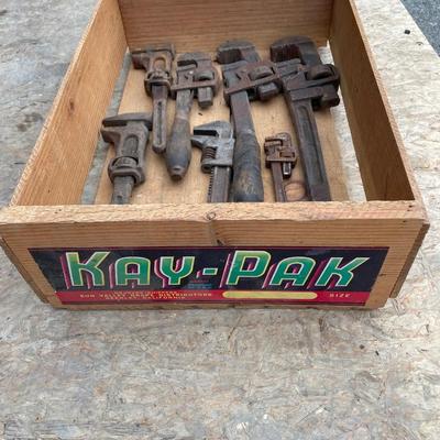 Antique pipe wrenches in wooden crate