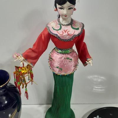 Oriental doll with a vase and a decorative plate