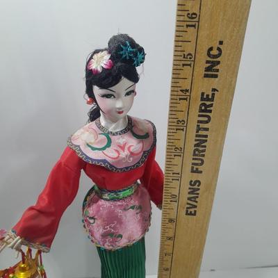 Oriental doll with a vase and a decorative plate