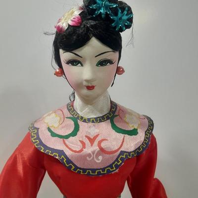 Oriental doll with a vase and a decorative plate