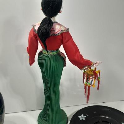 Oriental doll with a vase and a decorative plate
