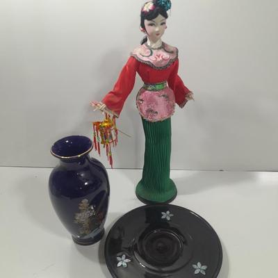 Oriental doll with a vase and a decorative plate