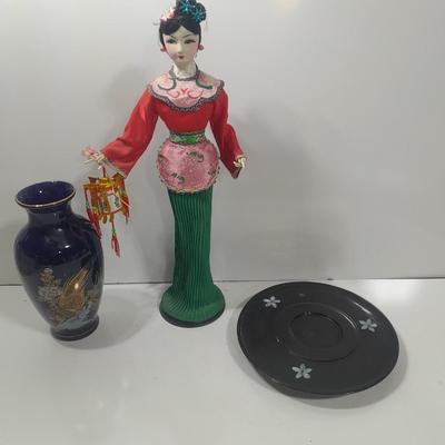 Oriental doll with a vase and a decorative plate