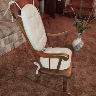 ROCKING CHAIR WITH NICE CUSHIONS AND A VASE W/FOLIAGE