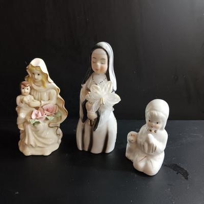 Porcelain religious figures -- Nunn -- girl praying with sheep -- and lady holding child.