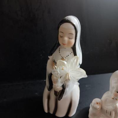 Porcelain religious figures -- Nunn -- girl praying with sheep -- and lady holding child.