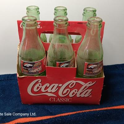 Denver Bronco's Back-to-Back Superbowl coca cola bottles in case with a Bronco's towel and Christmas hat