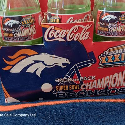 Denver Bronco's Back-to-Back Superbowl coca cola bottles in case with a Bronco's towel and Christmas hat