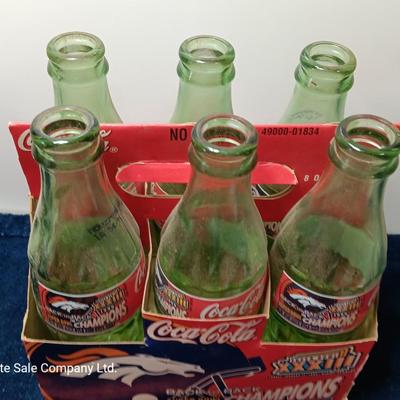 Denver Bronco's Back-to-Back Superbowl coca cola bottles in case with a Bronco's towel and Christmas hat