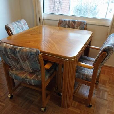 WOODEN DINING TABLE W/4 CHAIRS ON CASTERS AND 1 LEAF