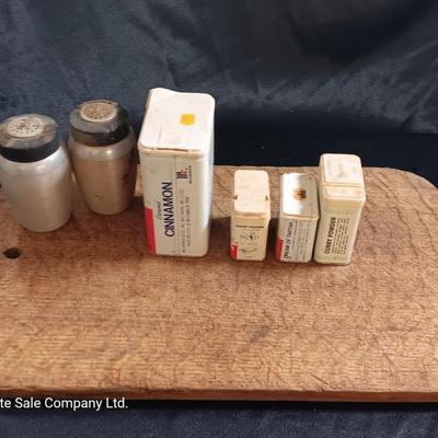 Primitive wooden cutting board with tin spice containers and aluminum salt & pepper shakers
