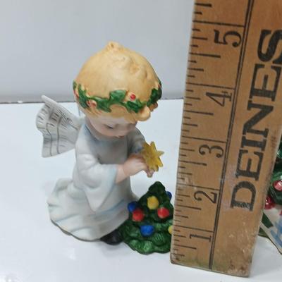 Vintage blonde angel putting star on Christmas tree figurine with tree canister
