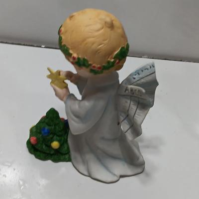 Vintage blonde angel putting star on Christmas tree figurine with tree canister