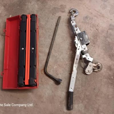 Come a long and tire iron / pry bar with orange safety triangles in a storage box