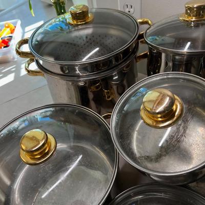 Large set of Pots & Pans Cuisine Cookware with Gold Accent on Knobs.