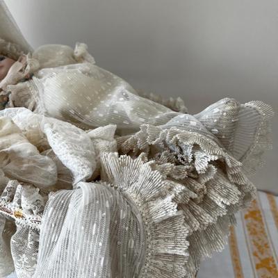 Porcelain Doll in an Antique Swinging Doll Bassinet