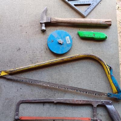 Assortment of tools - Bow saw- Hack saw - cloth measuring tape - hammer - and more