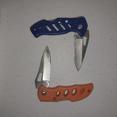 Four different pocketknives and a lasered antelope on tile