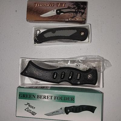 Four different pocketknives and a lasered antelope on tile